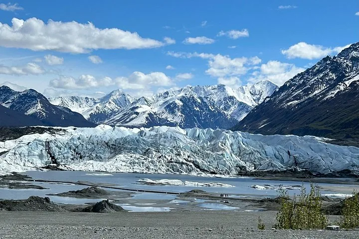 Wide landscape view of Matanuska Glacier with a small lake and mountains.